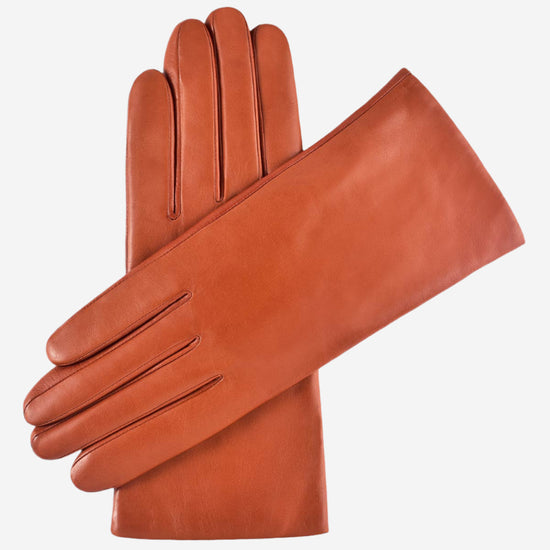 A pair of terra cotta colored Italian lambskin leather gloves with cashmere lining, displayed against a white background.